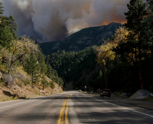 WIldfire Smoke smoke coming up behind mountains because of a wildfire